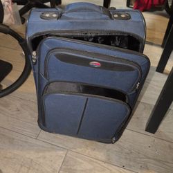 The item in the image is a navy blue softside suitcase from the American Tourister brand, specifically matching models from sets like the American Tou