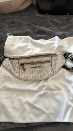 This Michael Kors waistpack features a white and beige signature logo print design.