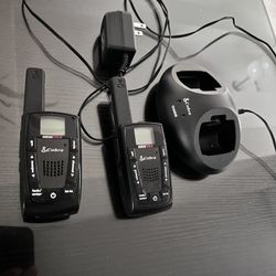 a set of Cobra microTALK two-way radios with their dual charging base and power adapter