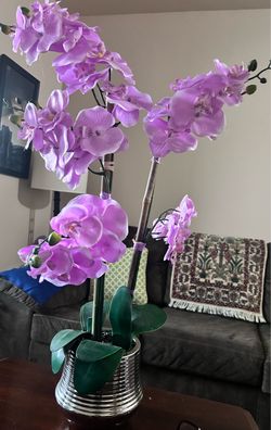 A beautiful metal pot and a very beautiful artificial orchid.