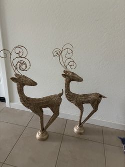Set up two tall, gold Christmas reindeers decor