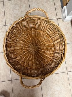 Large round wicker basket featuring two sturdy twisted-loop handles and a detailed woven base.