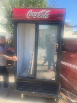 commercial coca cola refrigerator and a black commercial refrigerator