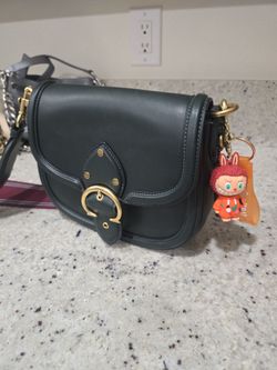 Green Coach saddle bag with Labubu charm