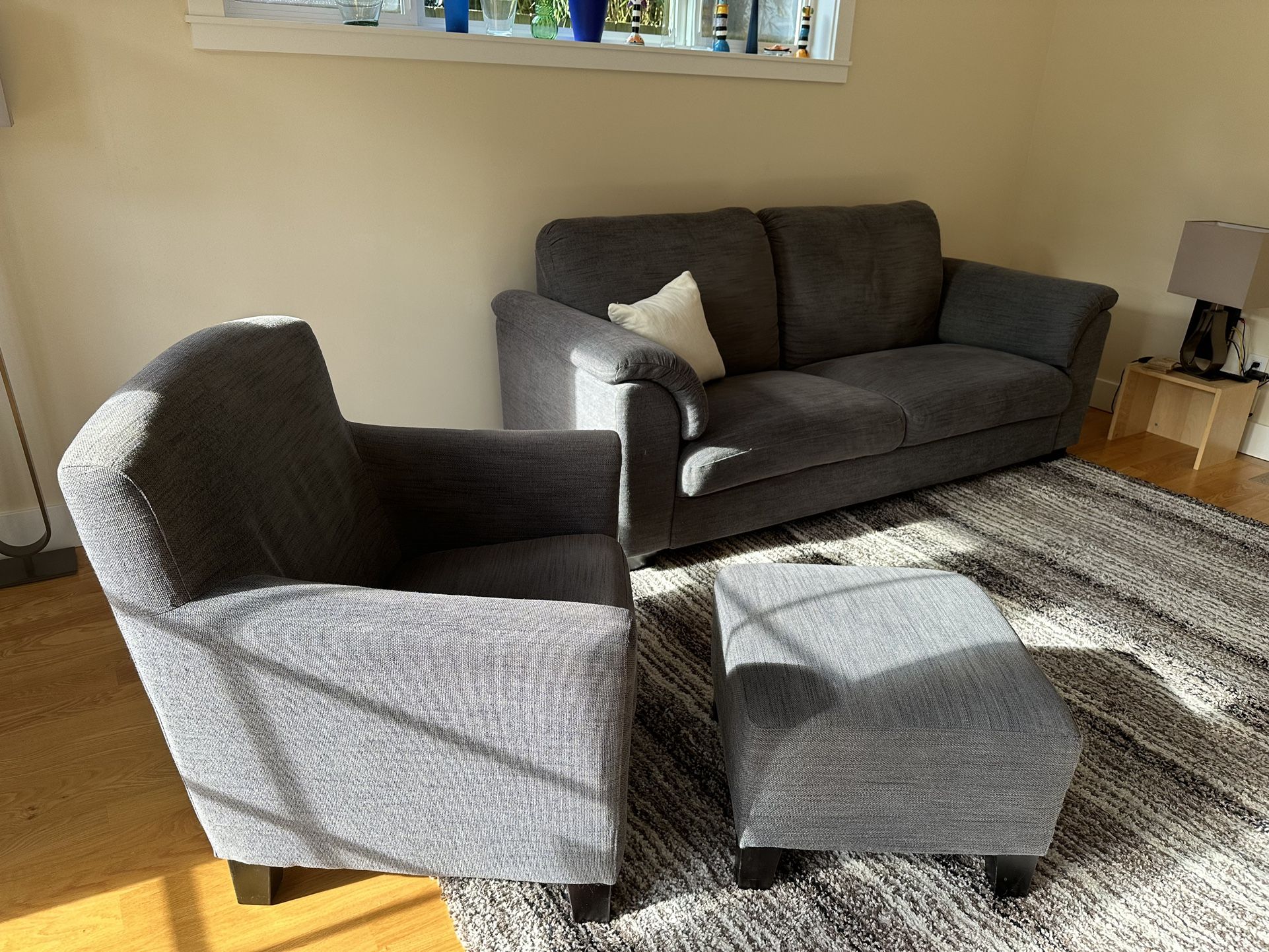 Grey IKEA sofa with matching armchair and ottoman 