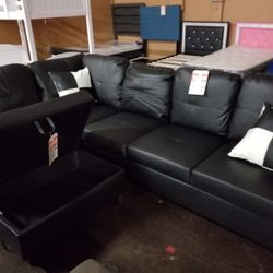 Contemporary black faux leather sectional with a matching storage ottoman
