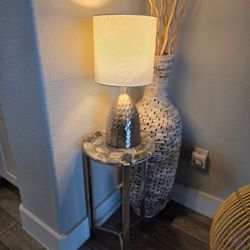 Chrome legs, stone top accent table with a lamp