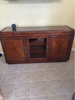 Wooden console/cabinet  with glass door. Will look great displaying a TV or under a TV on a wall. BEST OFFER