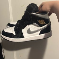  Nike Air Jordan 1 Mid SE in a Black/Metallic Silver-White colorway. Jordan 1