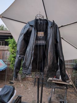 The black leather jacket is a vintage California Leather relaxed-fit bomber featuring a front zip closure and a ribbed elastic waistband.