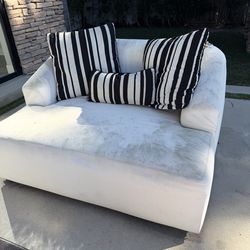 Two matching white couches with pillows