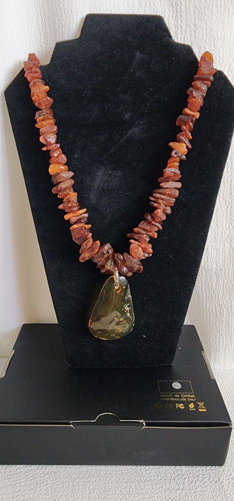 Stone amber necklace has a medallion