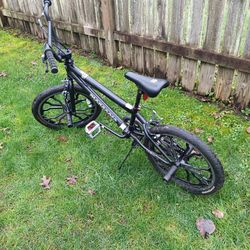 Black mongoose racing bike with pegs has 20" tires