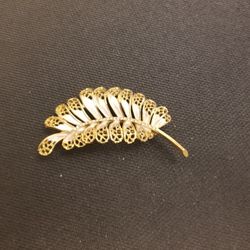 BSK lacy leaf brooch with pearlized enamel and a rhinestone stem in gold finish.
