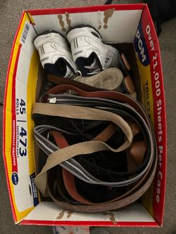 Caja con zapatos botas tenis y cintos.