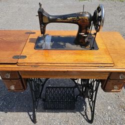 Singer 1910 sewing machine functional on its table 