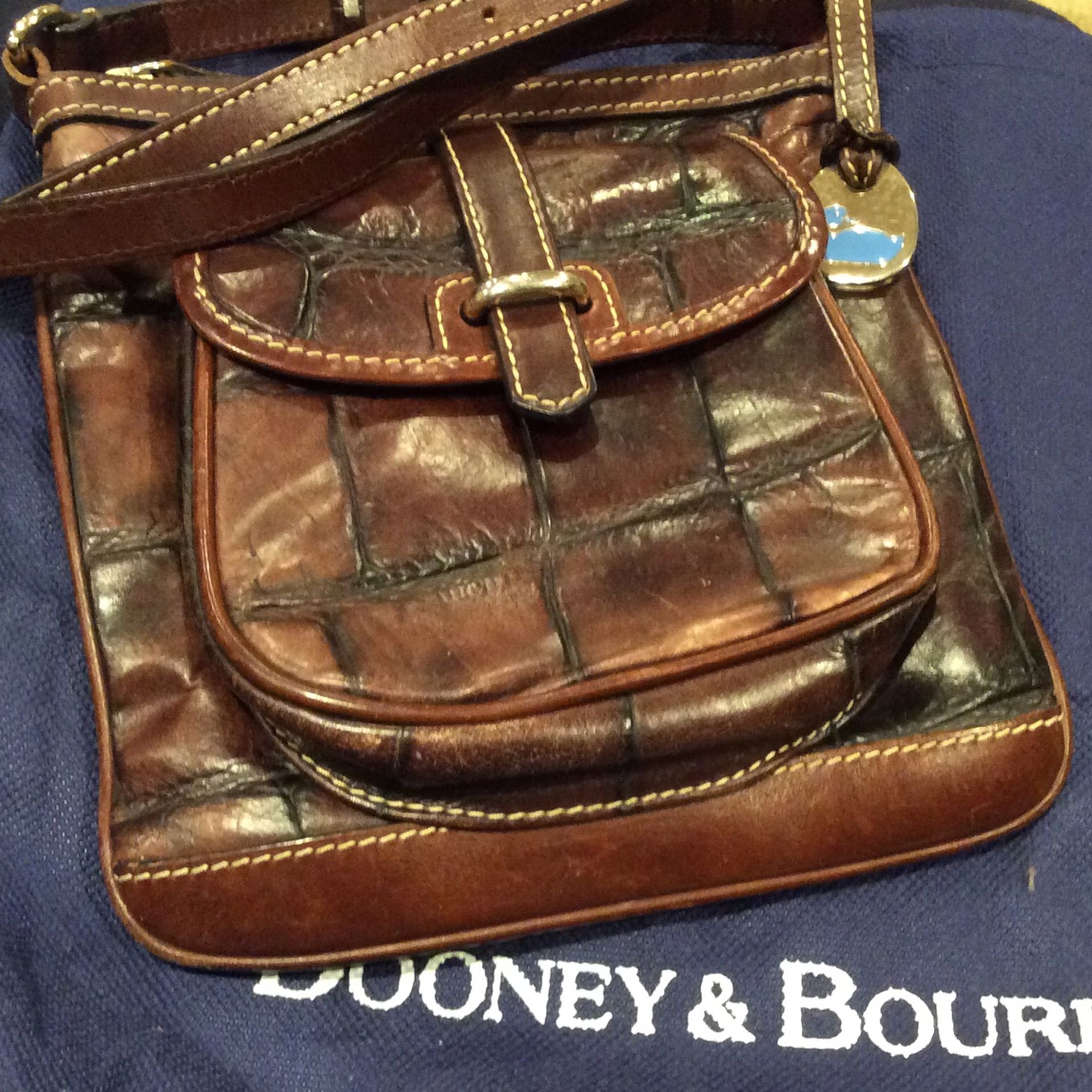 This 2tone Dark Brown/ Light Brown Leather small size H 7”x W 6” Crossbody Dooney and Bourke Purse comes with dust bag.