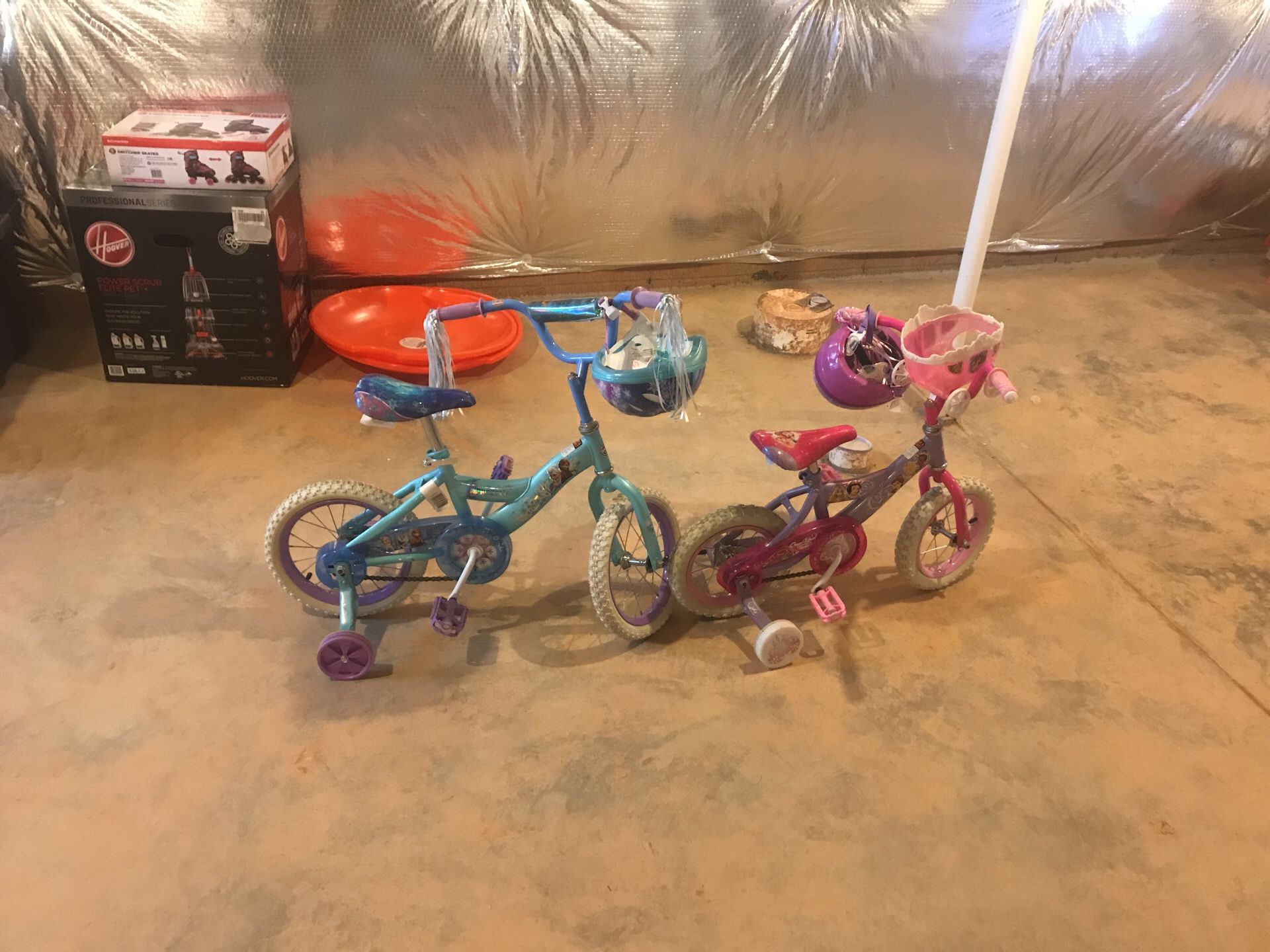 Two Girl Bikes with Helmets. Blue bike is frozen character and pink is princess