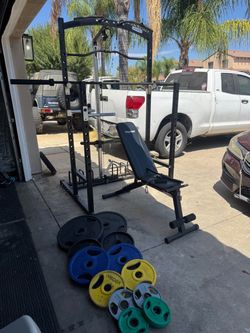 Bench press/squat rack with pulley system plus 230lbs of Olympic weights and 7ft bar