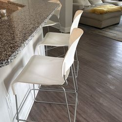 Three white bar stools