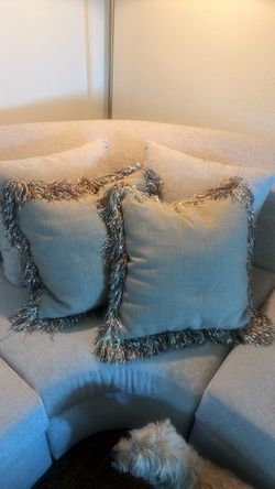 Two tan fringe pillows