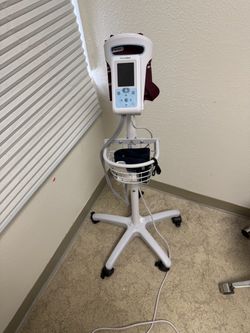Welch Allyn Spot Vital Signs monitor on a rolling stand, with BP cuff and accessories.