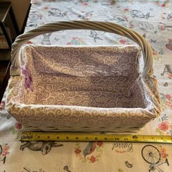 Vintage white wicker basket with a purple and white patterned fabric liner 