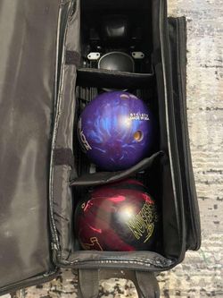 The image shows a bowling bag (a little damaged) containing two bowling balls and two Cobra wrist wraps. The bowling ball at the bottom is a Storm Obs