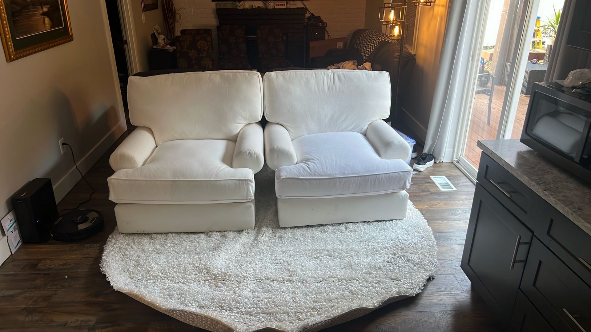 Two matching large white swivel rocking chairs