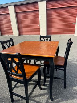 Square wooden high table and four chairs