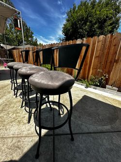 Black metal swivel high table stools with cushioned seats