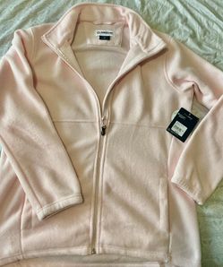 Magellan Outdoors women's fleece jacket in soft light pink. Lightweight and warm fleece with full-zip front and stand collar. Comfortable fit designed