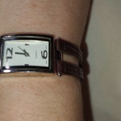 Quartz Watch With A Silver Face And A Brown Leather Band 