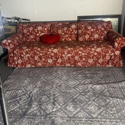Cozy red floral sleeper sofa with pull-out bed