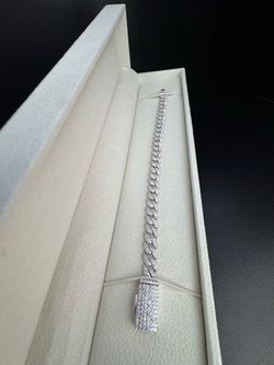 6mm, 6.5-inch iced-out Cuban link bracelet set with moissanite in solid 925 sterling silver.