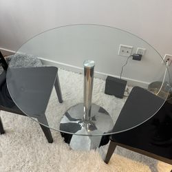 Round glass table with chrome base and/or black wood chairs