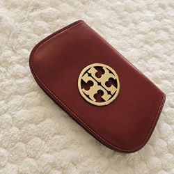 Tory Burch red bag
 Women's clutch bag on a chain over the shoulder.  Tory Burch.  The color of red wine.  Dimensions: width: 26 cm, height: 15 cm, de