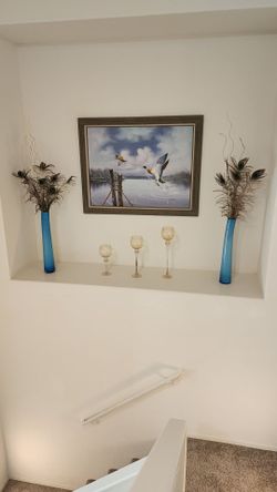 Slender blue vase set with peacock feathers