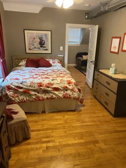 Rustic Wooden Queen Bed with Floral Bedding – Cozy Bedroom Style