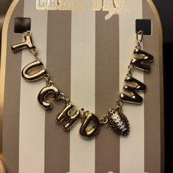 This is a gold-tone "CHAMP" bubble letter necklace with a crystal-encrusted football charm