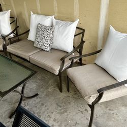 Beautiful four piece outdoor patio set in great condition. Includes loveseat, two lounge chairs, and tempered glass topped coffee table. Includes all 