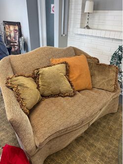 Pair of gold-colored Old Hickory Tannery sofas features textured fabric and a distinct curved camelback design
