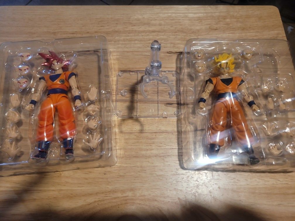 Two goku figures and stand