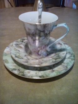 Tea or coffee cup and spoon with matching plates