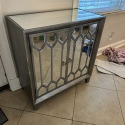 Mirrored accent cabinet with a distressed gray finish.
