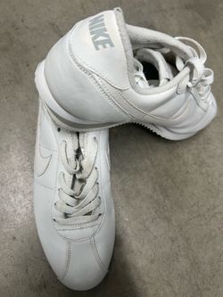 Used  Nike Cortez sneakers, likely the 'Triple White' leather version