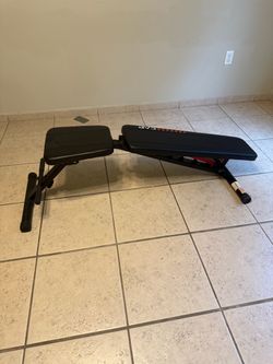 Incline/ decline bench with curling bar and 4x 45 lbs rubber coated weights for indoor use.