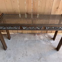 Vintage wood console table with a glass top and cane webbing