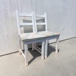Pair of IKEA HAUGA white dining chairs with patterned seat cushions