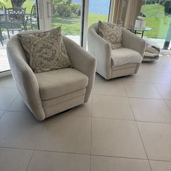 Two swivel arm chairs